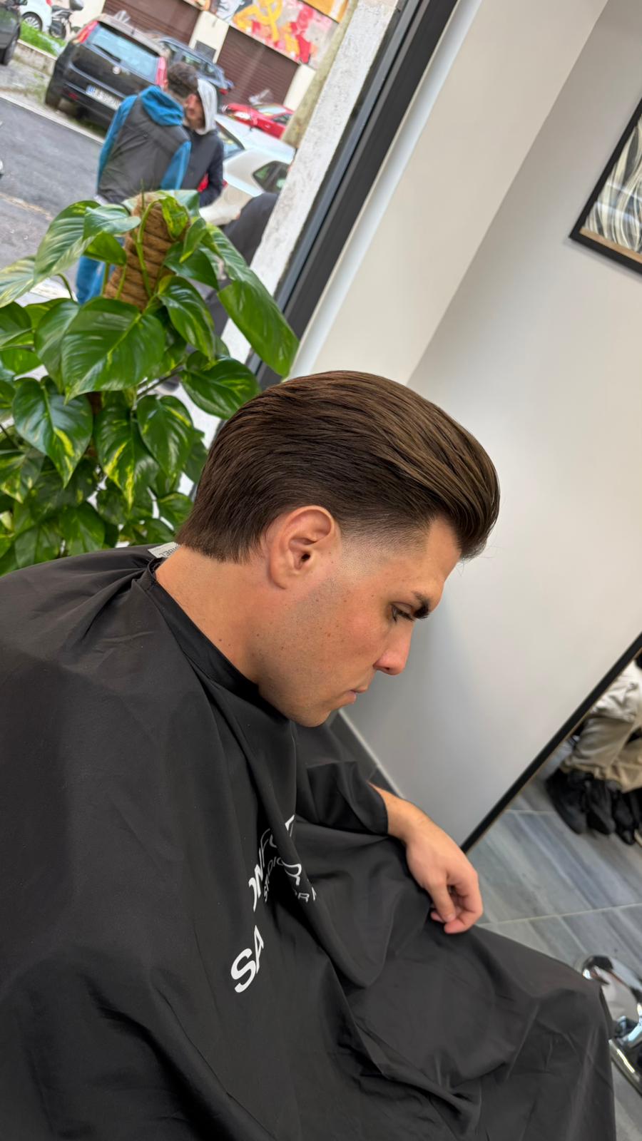 Fade classico con capelli pettinati all'indietro